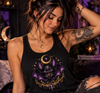 Female model wearing a black Vespertine Moonwatcher racerback tank featuring a purple celestial bat, crescent moon, stars, and ornate gold details in a moody gothic setting.