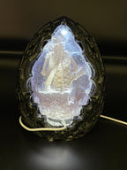 Back view of the Shardlurker Specimen Night Light with the translucent blue resin egg illuminated, showing the fetal specimen inside and the attached power cord
