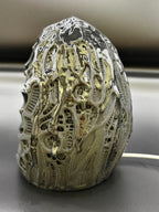 Left side angled view of the Shardlurker Specimen Night Light showing the glossy resin-finished containment egg and push-button power cable