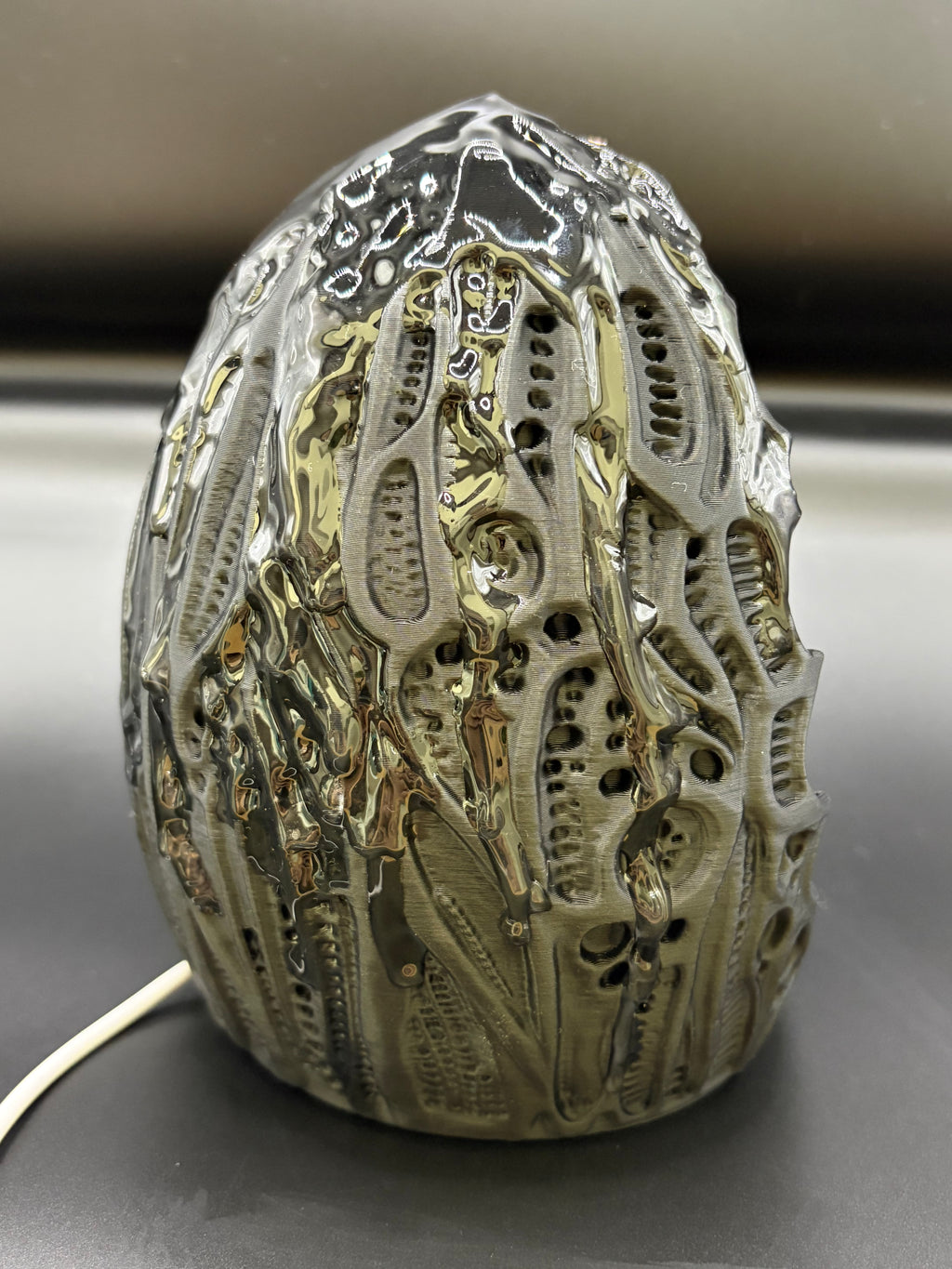 Right angled view of Shardlurker Specimen Night Light showing glossy resin-finished containment egg texture and power cable