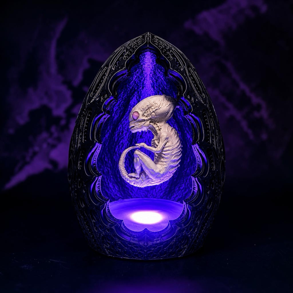 The 3D Stitch alien embryo sculpture in an ornate gothic egg casing with a vibrant purple LED glow for sci-fi decor.