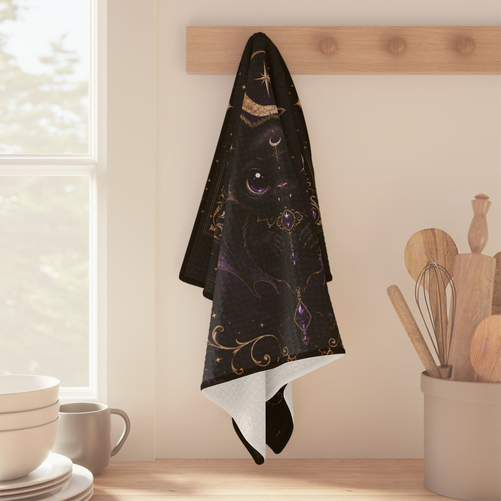 Vespertine Gothic Moon Bat microfiber tea towel hanging in a kitchen, featuring a black bat, crescent moon, stars, and purple celestial details