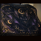 Close-up of Vespertine Gothic Moon Bat velveteen plush blanket featuring a black bat, purple wings, crescent moons, stars, and ornate gold celestial details