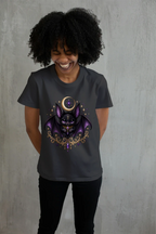 Model wearing the Vespertine Moonwatcher charcoal T-shirt featuring a purple gothic bat, crescent moon, stars, and ornate gold celestial details